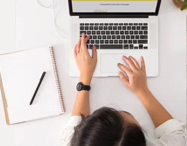 Entreprise individuelle: une personne travaillant sur un ordinateur portable dans un bureau, avec un bloc note, une tasse de café.